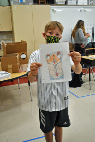 A student shows off his artwork for Sketch Day!