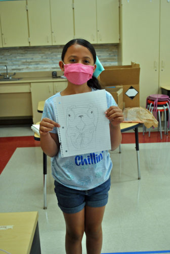 A student shows off her artwork for Sketch Day!